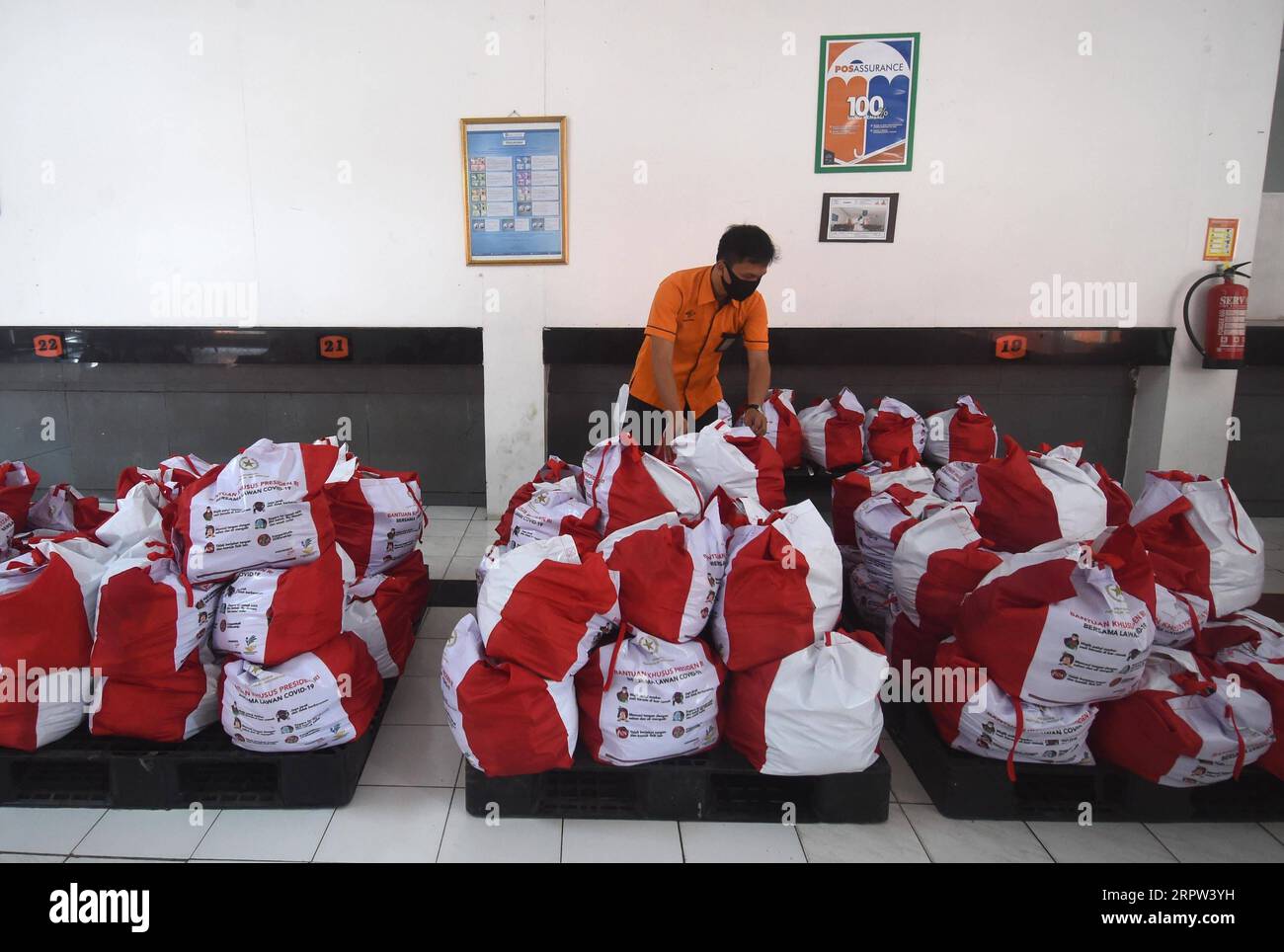 200421 -- GIACARTA, 21 aprile 2020 -- Un membro dello staff della società postale statale PT POS Indonesia organizza pacchetti di assistenza sociale a Giacarta, Indonesia, 21 aprile 2020. I pacchetti di assistenza sociale da parte del governo saranno distribuiti ai residenti di Giacarta cooperati con PT POS Indonesia e ai conducenti di motocicli-taxi online. Foto di /Xinhua INDONESIA-JAKARTA-CORONAVIRUS-ASSISTANCE Zulkarnain PUBLICATIONxNOTxINxCHN Foto Stock