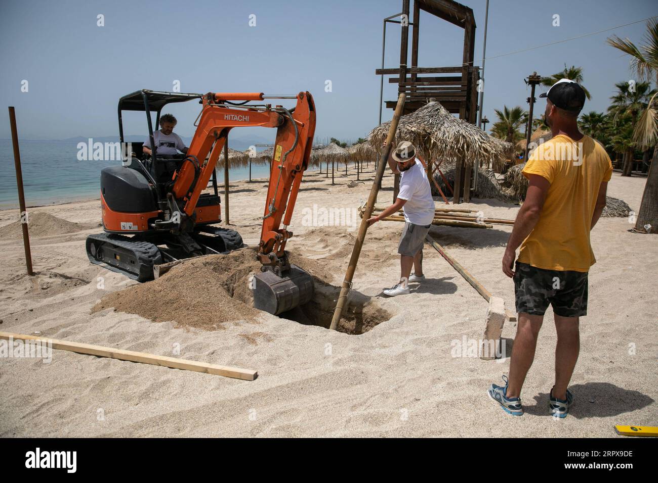 200514 -- ATENE, 14 maggio 2020 Xinhua -- i lavoratori installano un ombrello sulla spiaggia organizzata di Alimos, a sud di Atene, in Grecia, il 14 maggio 2020. Mercoledì i funzionari greci hanno annunciato che a partire dal 16 maggio le 515 spiagge organizzate del paese apriranno sotto restrizioni per evitare il sovraffollamento. Il Ministero della salute greco ha riferito giovedì che il numero di infezioni da COVID-19 ha raggiunto 2.770 e ci sono stati 156 decessi dall'inizio dell'epidemia nel paese il 26 febbraio. Foto di Lefteris Partsalis/Xinhua GREECE-BEACH-REOPENING PUBLICATIONxNOTxINxCHN Foto Stock