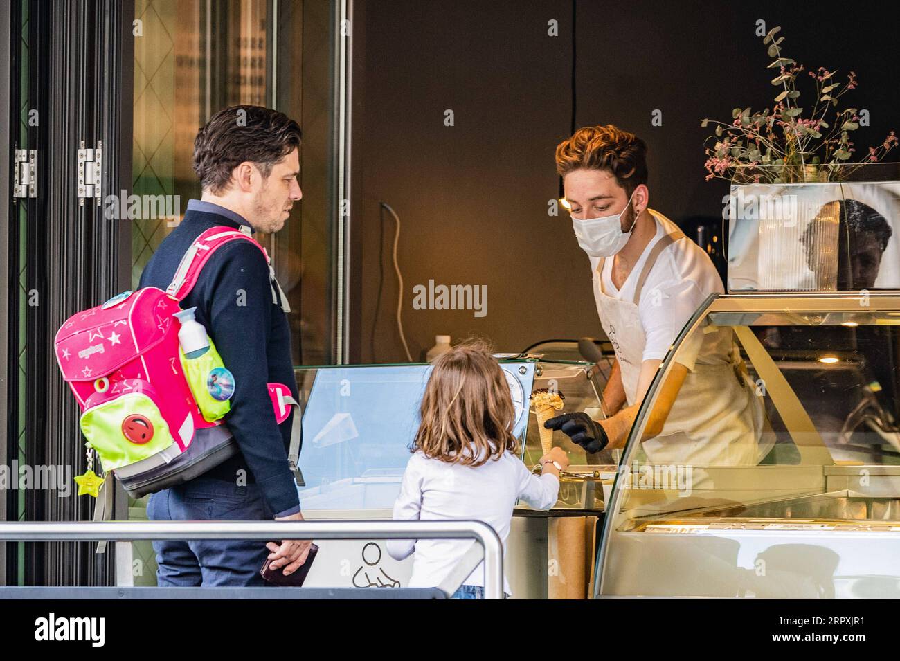 200527 -- BERLINO, 27 maggio 2020 Xinhua -- Un membro dello staff di una gelateria passa un cono gelato a una ragazza di Berlino, capitale della Germania, 26 maggio 2020. Il governo federale tedesco e i 16 stati hanno concordato in linea di principio di mantenere in vigore le restrizioni di contatto con il coronavirus fino a giugno 29, l'Ufficio stampa federale ha annunciato martedì sera. Foto di Binh Truong/Xinhua GERMANY-BERLIN-COVID-19-CONTACT RESTRICTIONS-EXTENSION PUBLICATIONxNOTxINxCHN Foto Stock