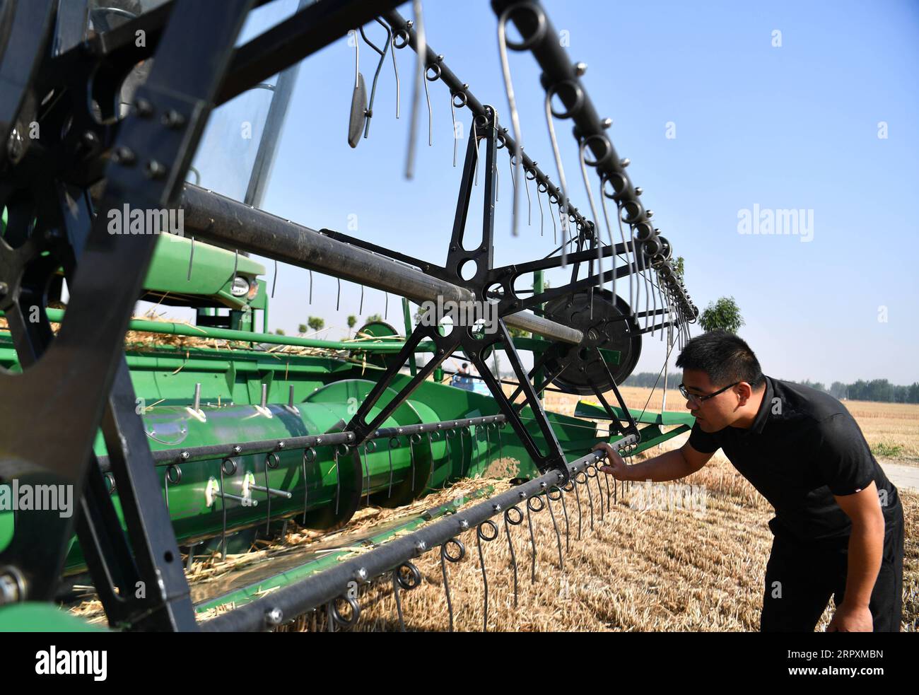 200528 -- ZHOUKOU, 28 maggio 2020 -- Wang Lianjie controlla una mietitrebbiatrice nel villaggio di Qianyuwa nella contea di Dancheng, nella Cina centrale nella provincia di Henan, 27 maggio 2020. Wang Lianjie, 31 anni, lavora come esperto di macchine agricole da cinque anni. Wang ha avuto la possibilità di condurre lavori di macchine agricole in tutto il paese fin da giovane perché suo padre lavorava anche come macchinista agricolo. Ispirato da suo padre, Wang prese la decisione di tornare nella sua città natale e fondò la sua cooperativa di macchine agricole nel 2015. Quando Wang entrò per la prima volta nel macchin agricolo Foto Stock