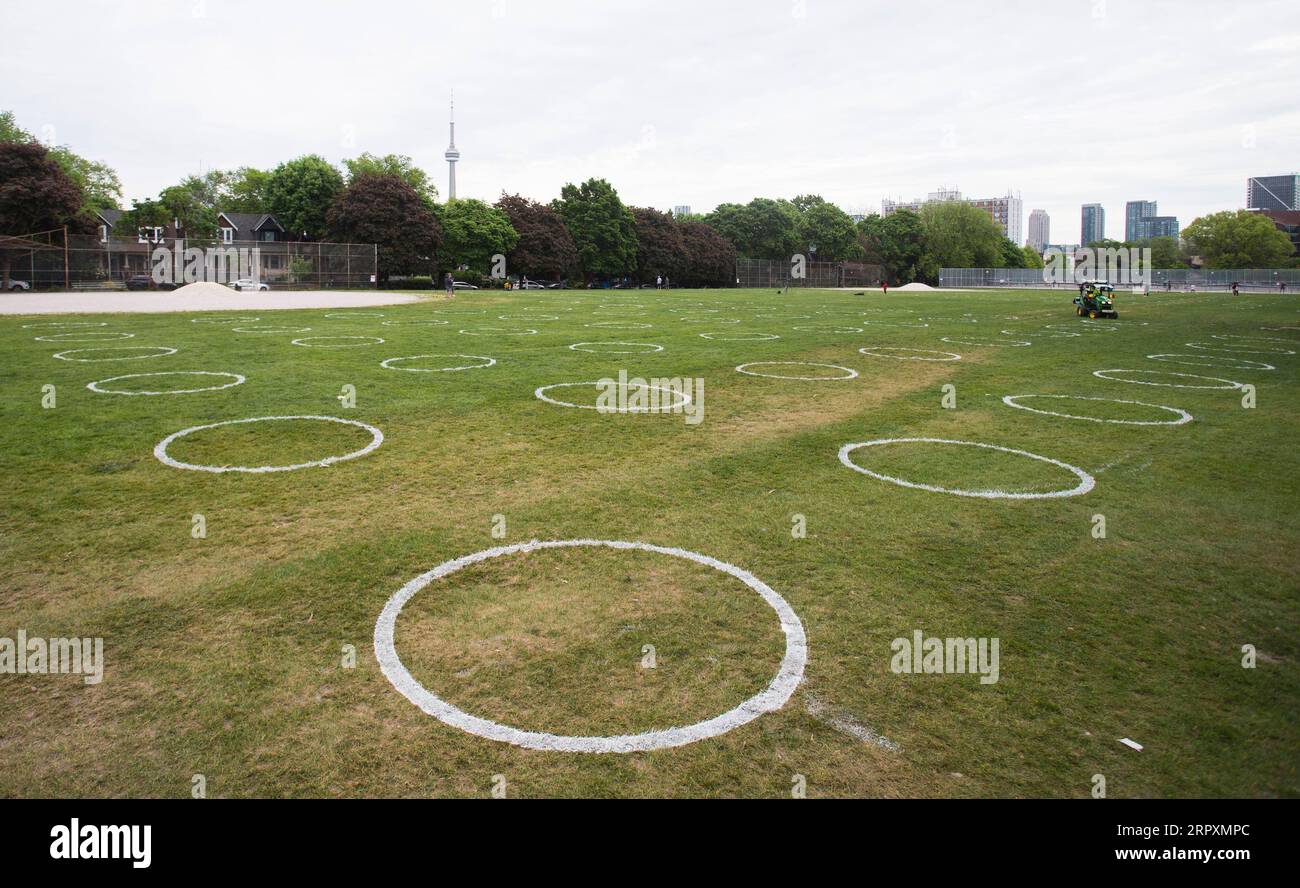200528 -- TORONTO, 28 maggio 2020 -- i cerchi bianchi sono dipinti sull'erba al Trinity Bellwoods Park di Toronto, Canada, il 28 maggio 2020. La città di Toronto ha dipinto cerchi sull'erba al Trinity Bellwoods Park come progetto pilota giovedì per incoraggiare le persone in distanziamento fisico durante l'epidemia di COVID-19. Foto di /Xinhua CANADA-TORONTO-COVID-19-PARK-PHYSICAL DISTANCING-CIRCLES ZouxZheng PUBLICATIONxNOTxINxCHN Foto Stock