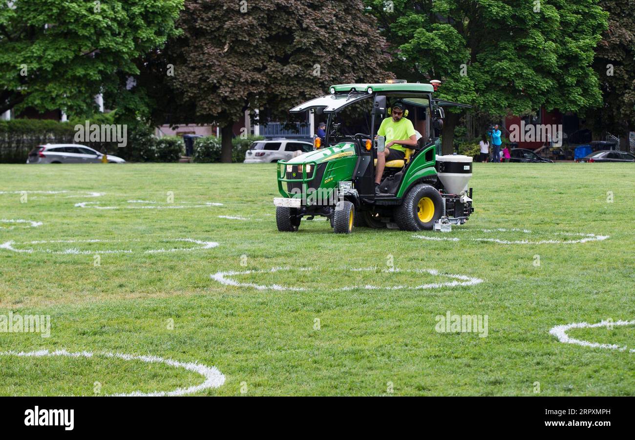 200528 -- TORONTO, 28 maggio 2020 -- Un lavoratore dipinge un cerchio bianco sull'erba al Trinity Bellwoods Park di Toronto, Canada, il 28 maggio 2020. La città di Toronto ha dipinto cerchi sull'erba al Trinity Bellwoods Park come progetto pilota giovedì per incoraggiare le persone in distanziamento fisico durante l'epidemia di COVID-19. Foto di /Xinhua CANADA-TORONTO-COVID-19-PARK-PHYSICAL DISTANCING-CIRCLES ZouxZheng PUBLICATIONxNOTxINxCHN Foto Stock