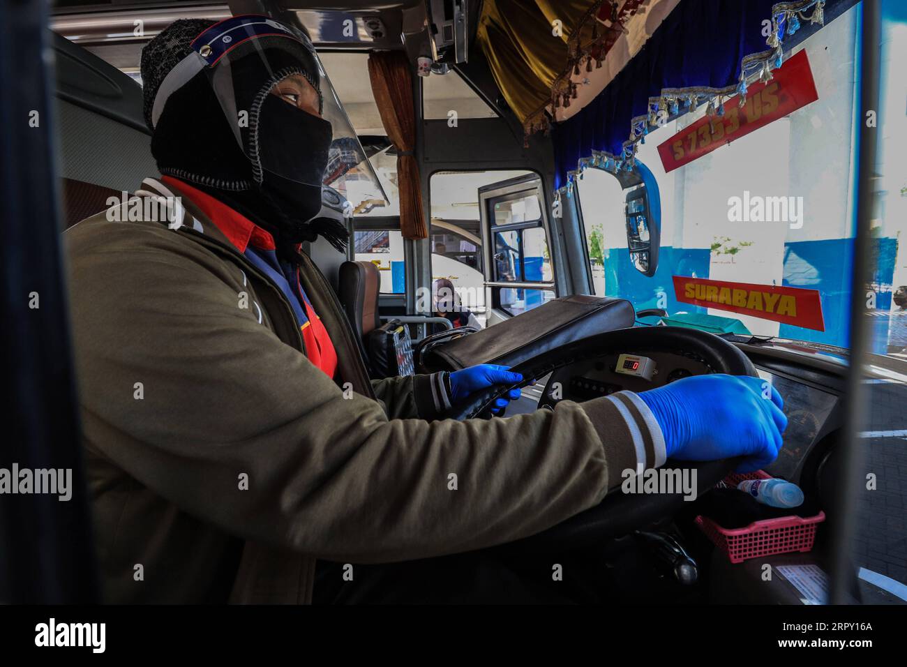 200609 -- SURABAYA, 9 giugno 2020 -- Un autista di autobus che indossa uno scudo facciale è visto alla stazione degli autobus di Purbaya a Surabaya, Indonesia, 9 giugno 2020. L’Indonesia ha gradualmente allentato le sue restrizioni durante la pandemia di COVID-19 nella speranza di un aumento delle attività commerciali, ma ha anche tenuto conto delle aree in cui i tassi di trasmissione rimangono a galla. Foto di /Xinhua INDONESIA-SURABAYA-PUBLIC TRANSPORT-COVID-19 SuryaxBetha PUBLICATIONxNOTxINxCHN Foto Stock