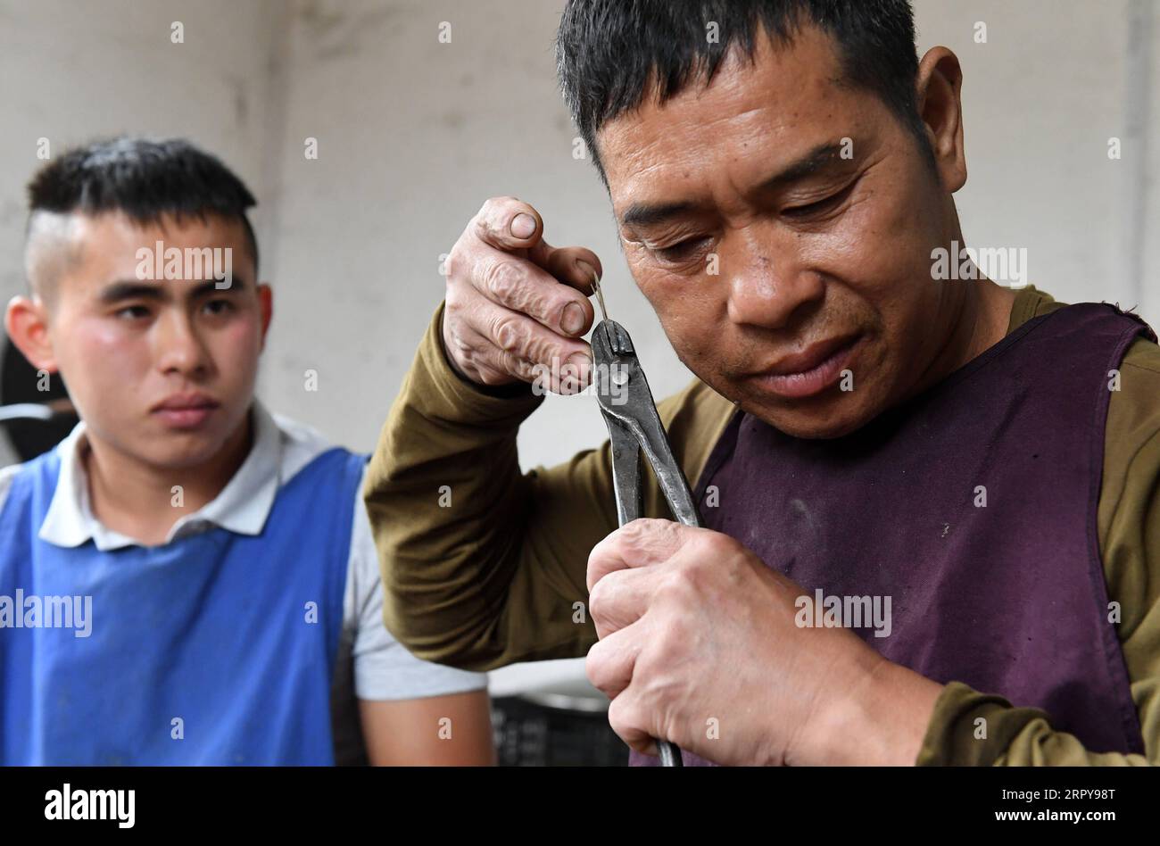 200621 -- PECHINO, 21 giugno 2020 -- Du Xinwen L guarda suo padre Du Qingren regolare una canna di Lusheng, uno strumento a vento a canna, nel villaggio di Xiaosang della contea autonoma di Rongshui Miao, nella regione autonoma di Guangxi Zhuang della Cina meridionale, 30 maggio 2019. PADRI DEL MONDO, TUTORE DI GIORNO, INSEGNANTE ED ENCOURAGER LUXBOAN PUBLICATIONXNOTXINXCHN Foto Stock