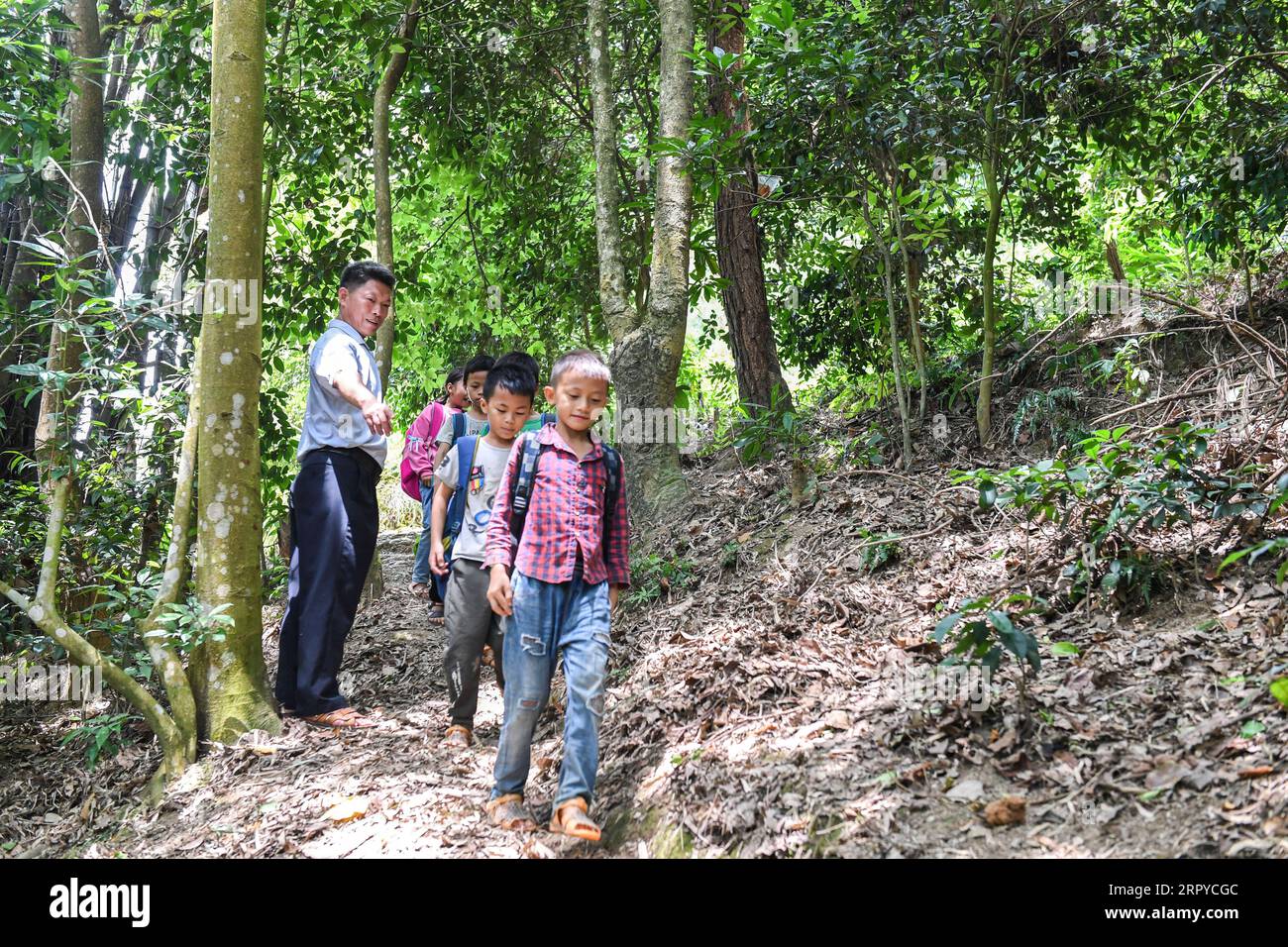 200625 -- NINGMING, 25 giugno 2020 -- Jiao Shengding accompagna gli studenti dopo la scuola mentre tornano a casa nella città di Aidian della contea di Ningming, nella regione autonoma del Guangxi Zhuang della Cina meridionale, 23 giugno 2020. Jiao Shengding, 52 anni, è l'unico insegnante presso il sito di insegnamento del villaggio di Zhangji, che si trova al confine tra Cina e Vietnam. Dopo essersi diplomato presso la scuola professionale secondaria della contea nel 1990, Jiao ha scelto di essere un insegnante presso il villaggio di Zhangji e da allora ha insegnato lì per 30 anni. Negli ultimi tre decenni, ha insegnato più di 400 alunni, la maggior parte Foto Stock