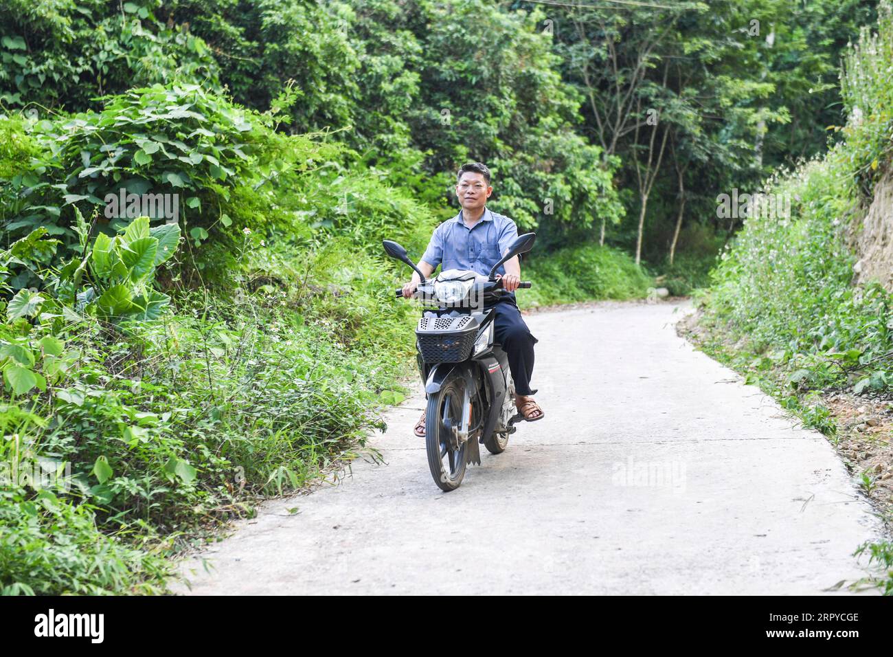 200625 -- NINGMING, 25 giugno 2020 -- Jiao Shengding torna a casa dopo la scuola nella contea di Ningming, nella regione autonoma del Guangxi Zhuang, nella Cina meridionale, 22 giugno 2020. Jiao Shengding, 52 anni, è l'unico insegnante presso il sito di insegnamento del villaggio di Zhangji, che si trova al confine tra Cina e Vietnam. Dopo essersi diplomato presso la scuola professionale secondaria della contea nel 1990, Jiao ha scelto di essere un insegnante presso il villaggio di Zhangji e da allora ha insegnato lì per 30 anni. Durante gli ultimi tre decenni, ha insegnato a più di 400 alunni, la maggior parte dei quali proveniva da Foto Stock