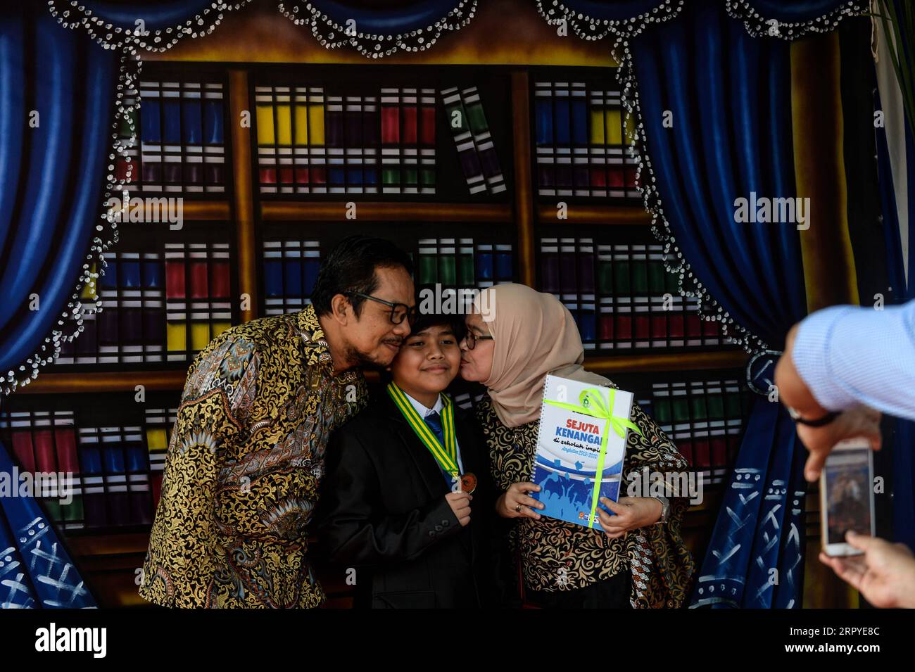 200627 -- GIACARTA, 27 giugno 2020 -- Uno studente di sesta elementare C tiene una medaglia e posa con i suoi genitori durante una sessione fotografica dopo una laurea in drive-thru nella scuola elementare in mezzo all'epidemia di COVID-19 alla Annajah School a South Jakarta, Indonesia, 27 giugno 2020. INDONESIA-JAKARTA-COVID-19-ELEMENTARE-DRIVE-THRU-GRADUATION AGUNGXKUNCAHYAXB. PUBLICATIONxNOTxINxCHN Foto Stock