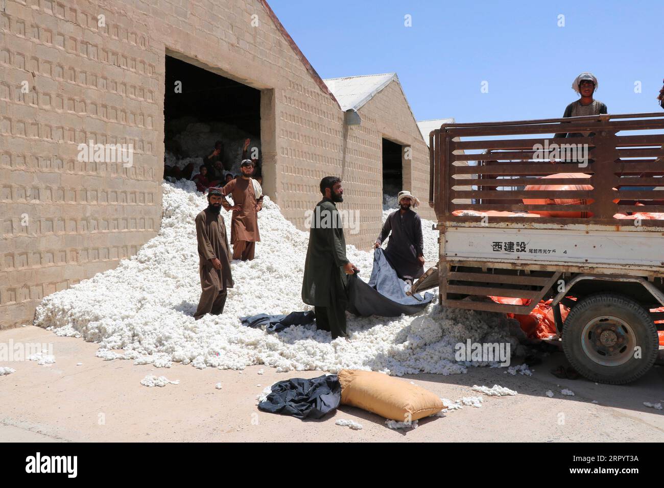 200714 -- LASHKAR GAH AFGHANISTAN, 14 luglio 2020 -- uomini afghani lavorano in una fabbrica di lavorazione del cotone a Lashkar Gah, capitale della provincia di Helmand, Afghanistan meridionale, 13 luglio 2020. La fabbrica di lavorazione del cotone comunemente nota come Tasadi Bost Helmand è l'unica unità industriale del suo tipo nella tormentata Helmand e nelle vicine province di Kandahar, Zabul e Uruzgan che è stata gravemente danneggiata e chiusa a causa della guerra prolungata. Il governo ha recentemente ricostruito la fabbrica per promuovere la coltivazione del cotone nella provincia colpita dalla militanza e fornire opportunità di lavoro per il pisello stanco della guerra Foto Stock