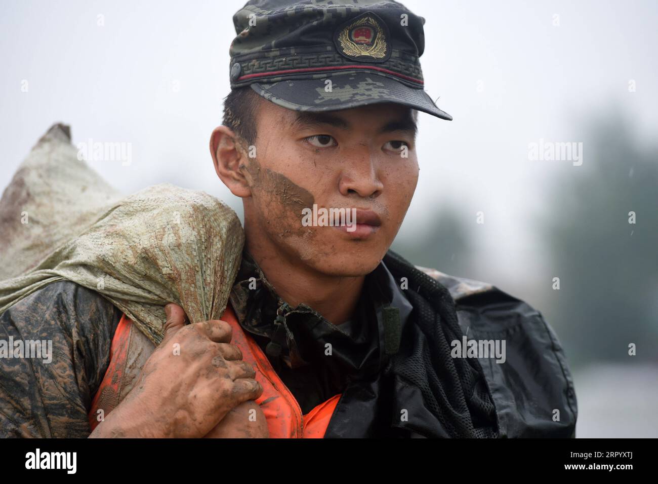200718 -- HEXIAN, 18 luglio 2020 -- un poliziotto armato porta un sacco di sabbia sull'argine del fiume Shiba nella contea di Hexian, nella provincia di Anhui della Cina orientale, 18 luglio 2020. Colpito da giorni di forti piogge, il livello dell'acqua del fiume Shiba, un affluente del fiume Yangtze, ha continuato a salire. CHINA-ANHUI-HEXIAN-CONTROLLO DELLE INONDAZIONI CN ZHOUXMU PUBLICATIONXNOTXINXCHN Foto Stock