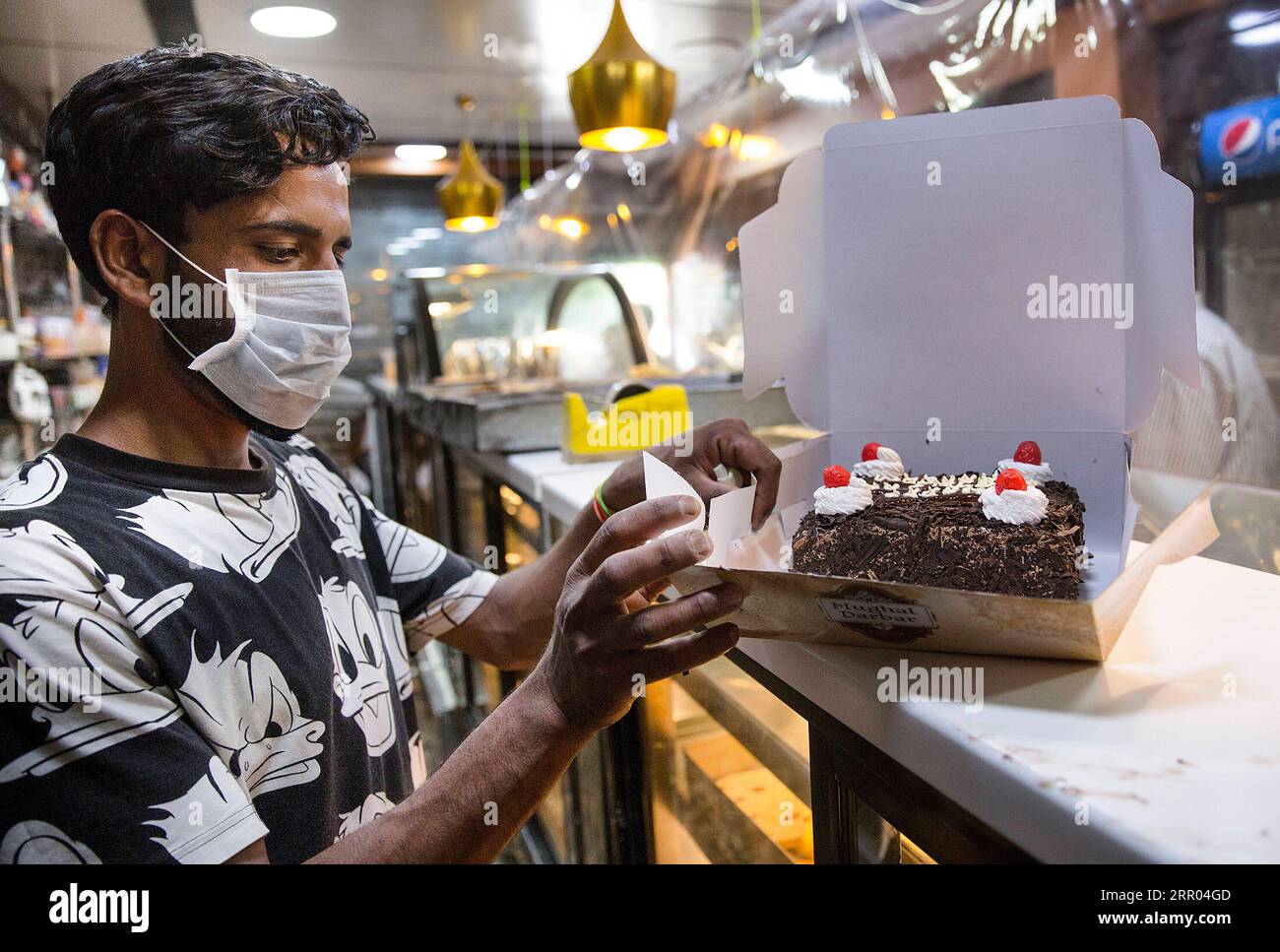 200728 -- SRINAGAR, 28 luglio 2020 -- Un assisstant del negozio confeziona una torta per un cliente in una panetteria davanti al festival Eid al-Adha a Srinagar, la capitale estiva del Kashmir controllato dagli indiani, 28 luglio 2020. KASHMIR-SRINAGAR-EID AL-ADHA-PREPARATION JAVEDXDAR PUBLICATIONXNOTXINXCHN Foto Stock