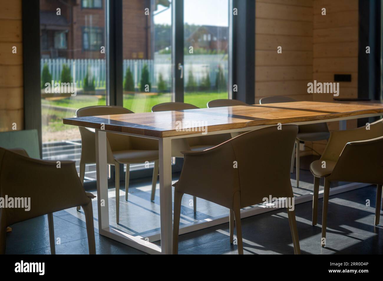 tavolo da pranzo in legno o da ufficio in una sala piena di luce, ripresa interna Foto Stock