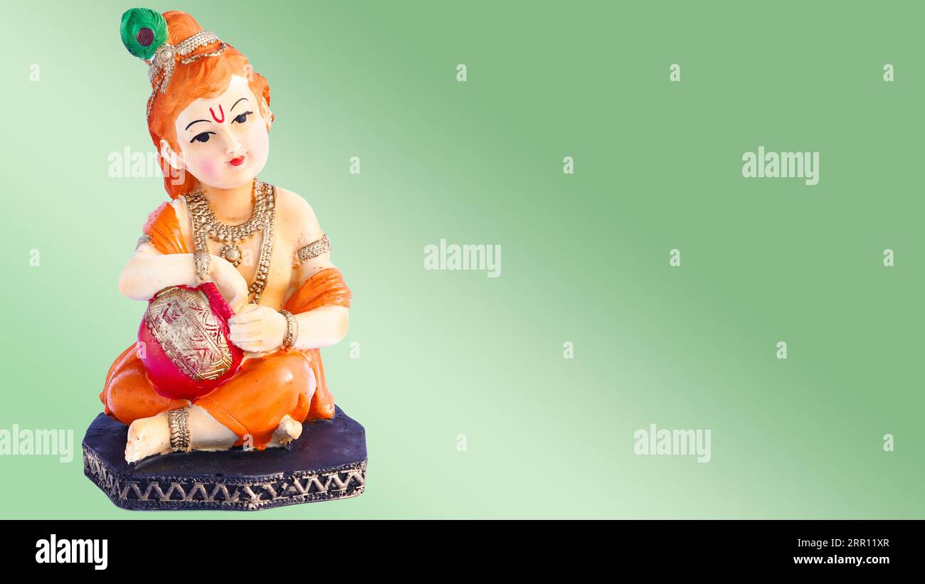 Krishna, Dio indù, su sfondo verde. Dio indù Kanha in statuetta di porcellana infantile isolato Foto Stock