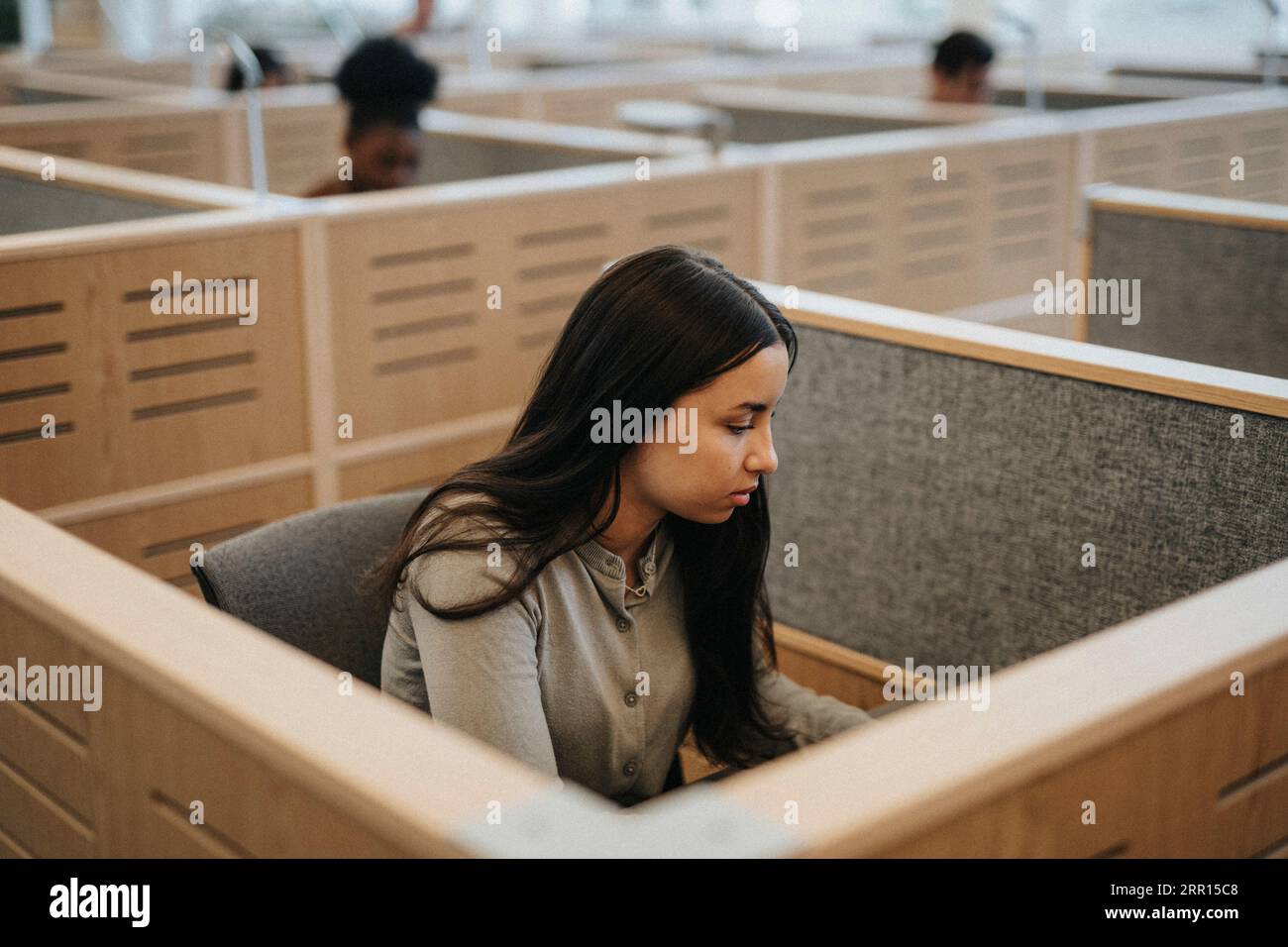 Adolescente che studia in biblioteca all'università Foto Stock