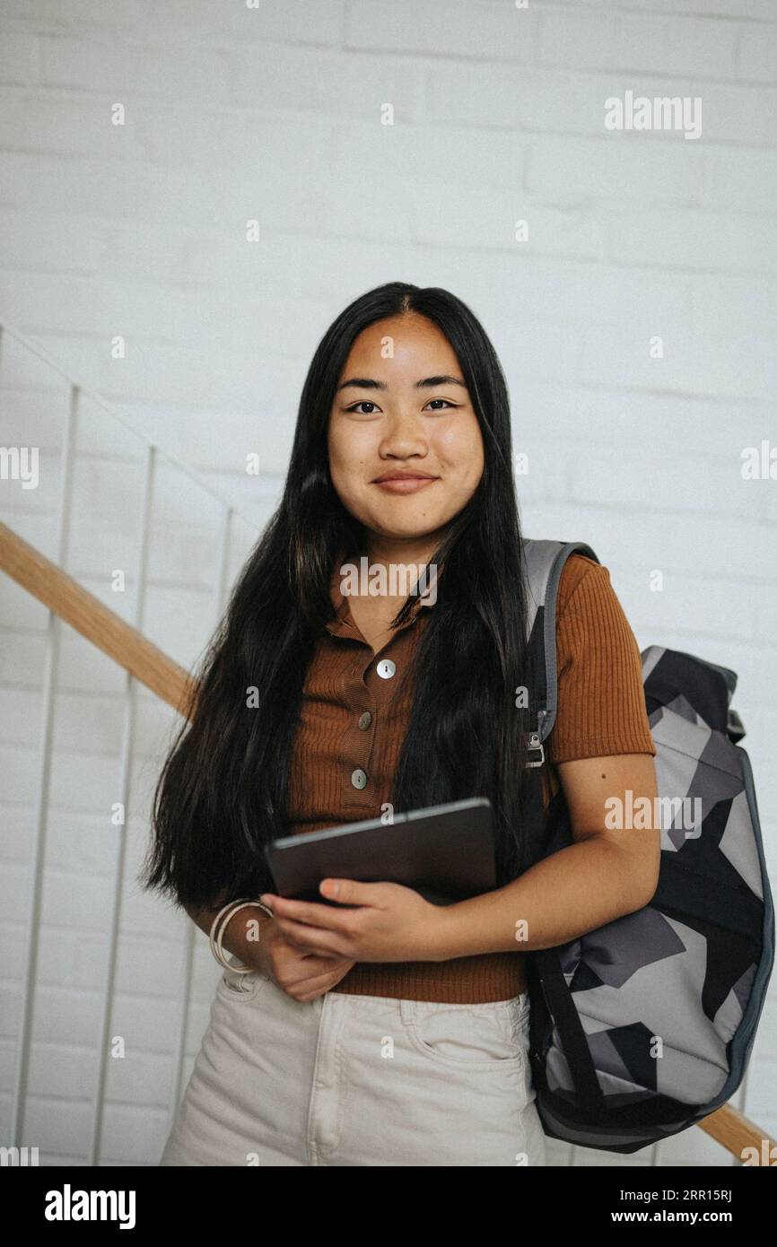 Ritratto di una studentessa sorridente che porta zaino all'università Foto Stock