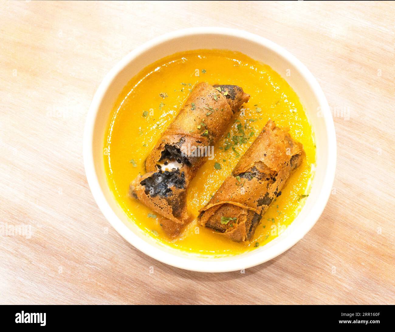 Involtini di salsiccia alla Morcilla con salsa d'arancia su un tavolo di legno. Foto Stock
