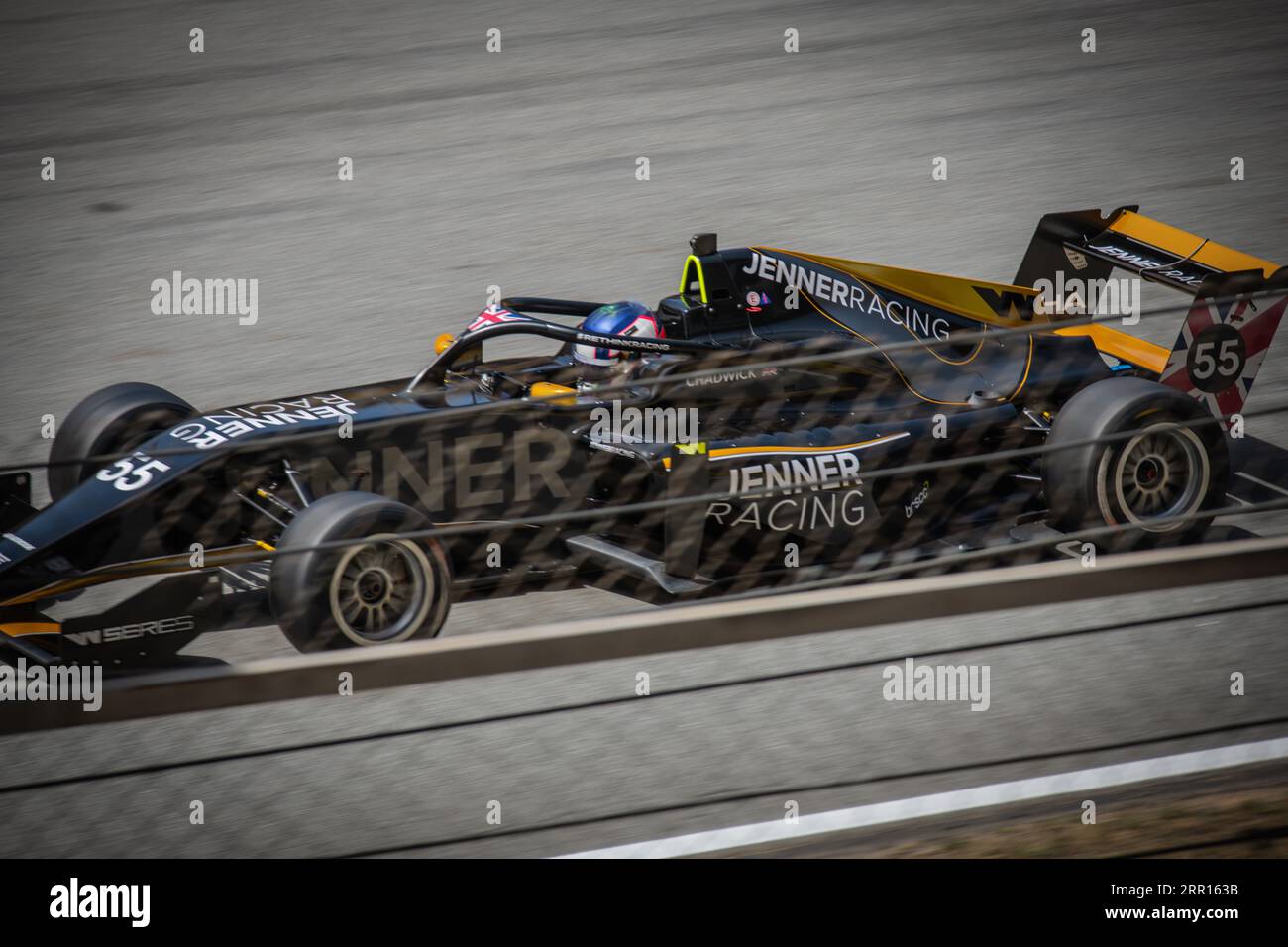 Una Jenner Racing Car nera corre un giro in un evento di F1 femminile. La fotografia cattura l'intensità e la velocità della competizione. Foto Stock