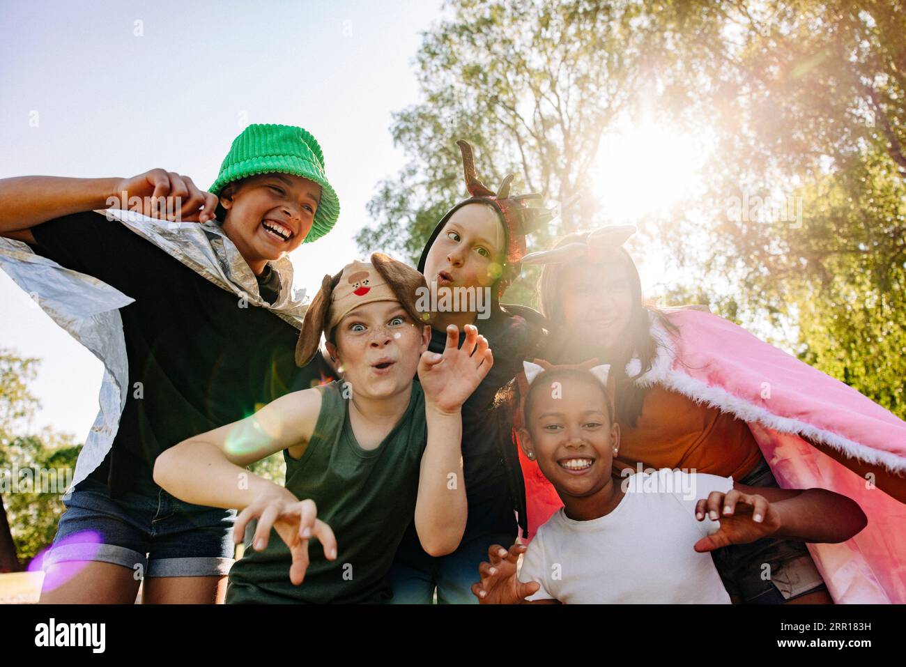Ritratto di bambini felici che gestiscono e fanno volti mentre giocano insieme al campo estivo Foto Stock