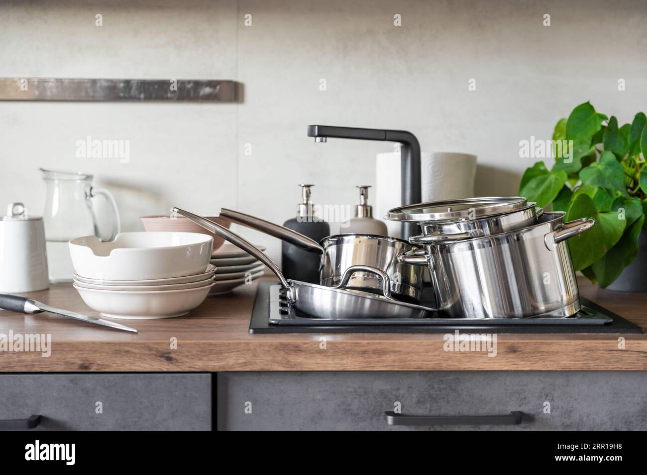 I piatti sporchi e gli elettrodomestici da cucina non lavati riempivano il lavandino della cucina Foto Stock