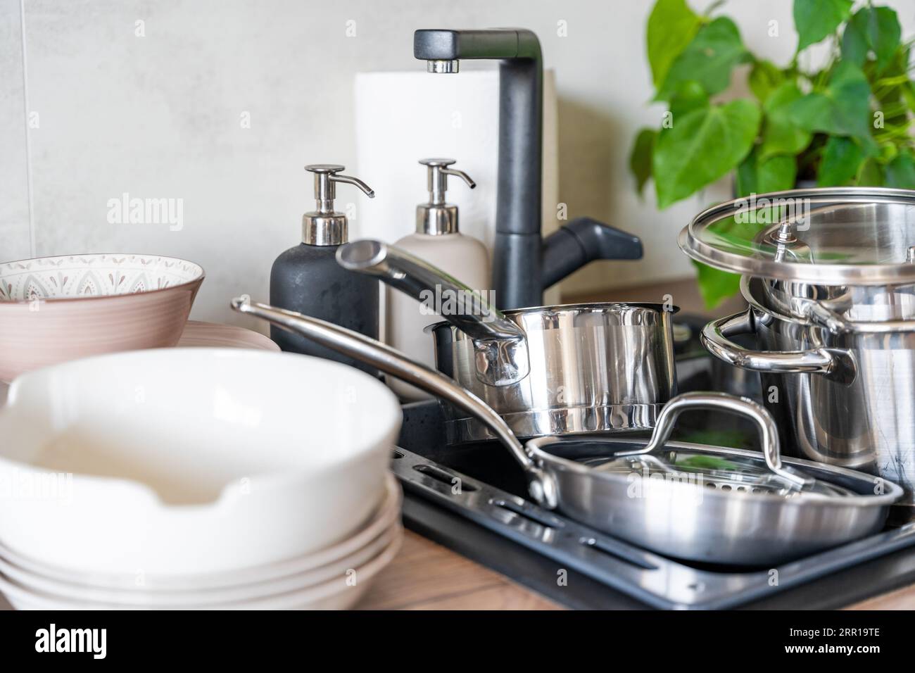 I piatti sporchi e gli elettrodomestici da cucina non lavati riempivano il lavandino della cucina Foto Stock