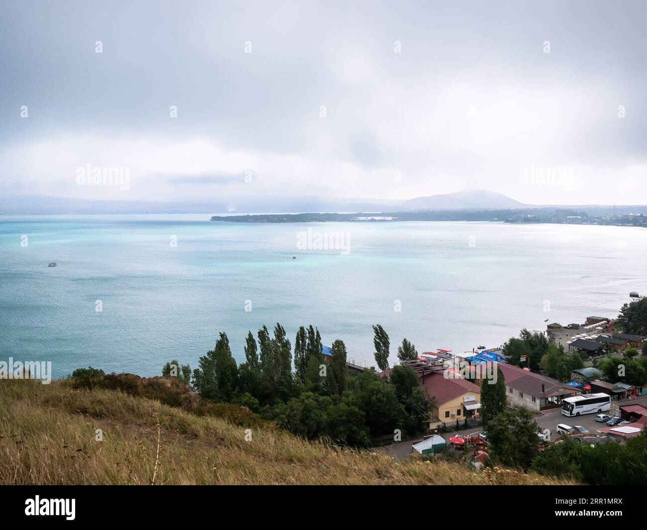 Sevan, Armenia - 25 agosto 2023: Vista sopra il lago Sevan e parcheggio dal monastero di Sevanavank nelle nuvole giornate estive, Armenia Foto Stock
