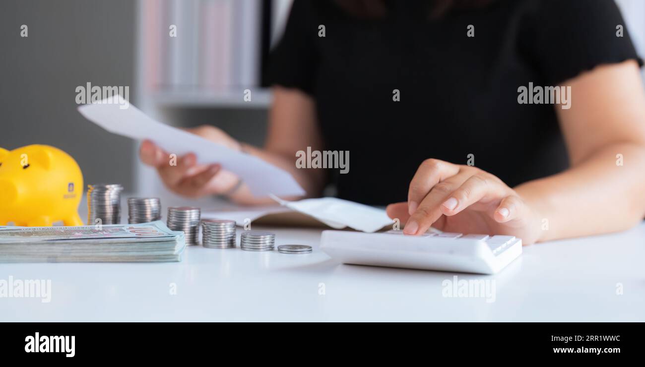 le donne d'affari tengono un registro delle sue entrate e spese, pianifica le sue finanze utilizzando i suoi risparmi mensili per acquistare fondi per farlo crescere più velocemente Foto Stock