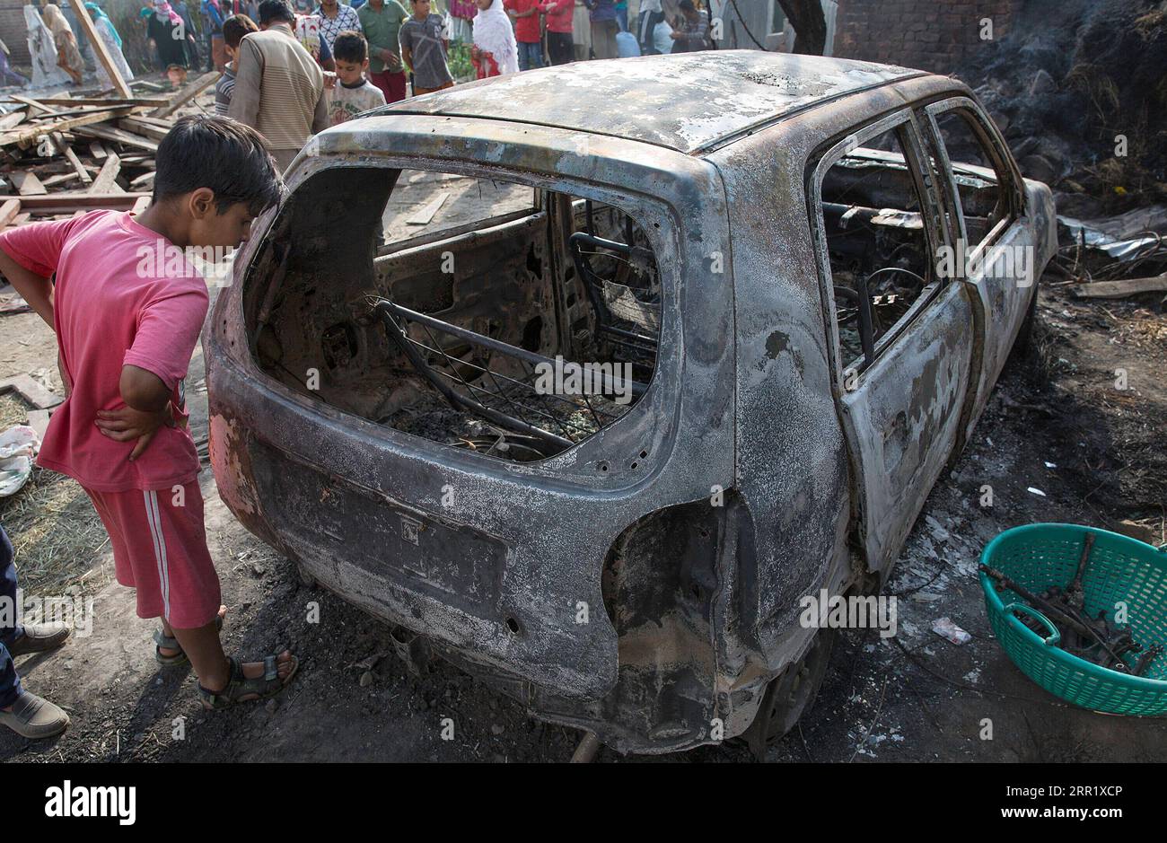 200925 -- SRINAGAR, 25 settembre 2020 -- Un ragazzo guarda un'auto bruciata durante uno scontro a fuoco nel villaggio Sirhama del distretto di Anantnag, circa 68 km a sud di Srinagar, Kashmir controllato dagli indiani, 25 settembre 2020. Due militanti sono stati uccisi venerdì in uno scontro a fuoco nel Kashmir controllato dagli indiani, ha detto la polizia. KASHMIR-ANANTNAG-UNREST JavedxDar PUBLICATIONxNOTxINxCHN Foto Stock