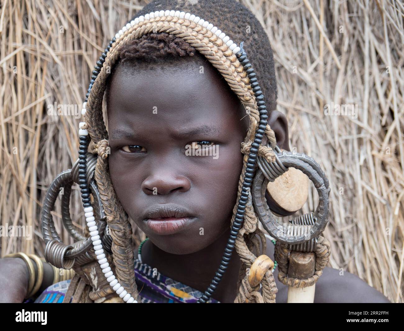 Ragazzo della tribù Mursi con copricapo, ritratto, Etiopia Foto Stock