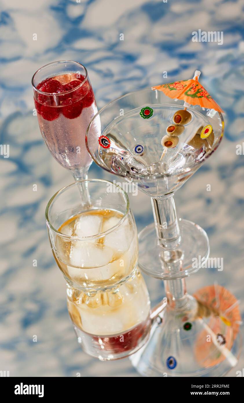 Bevande alcoliche su superficie riflettente su sfondo modellato Foto Stock