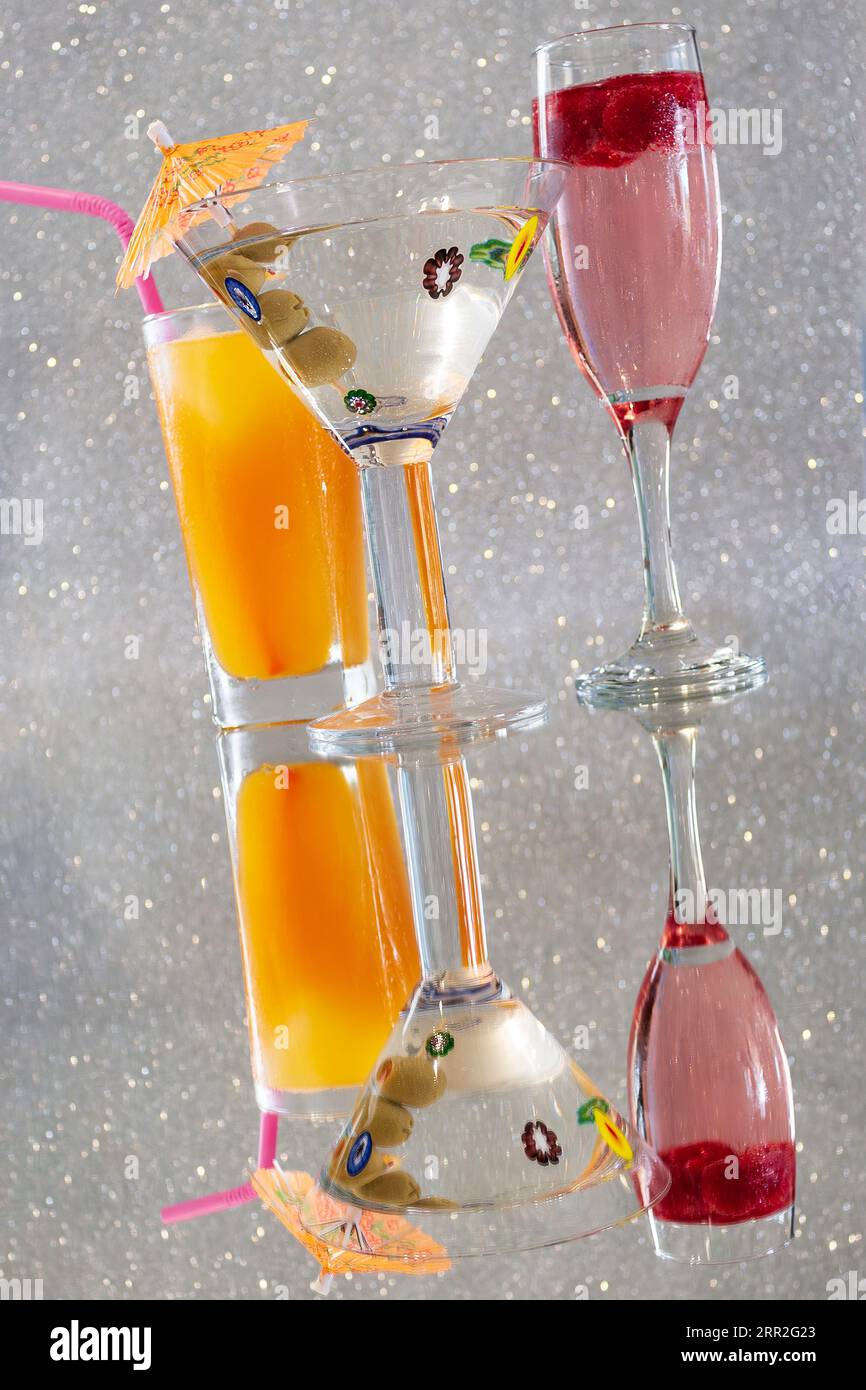 Bevande alcoliche su superficie riflettente con sfondo scintillante Foto Stock