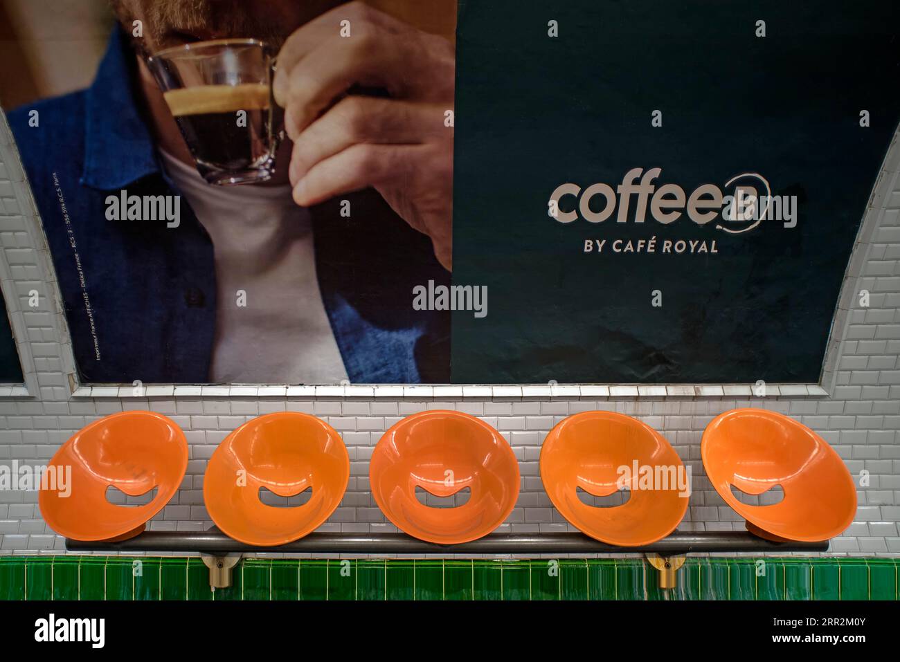 Sedili arancioni di fronte a un grande poster della metropolitana, Parigi, Francia Foto Stock