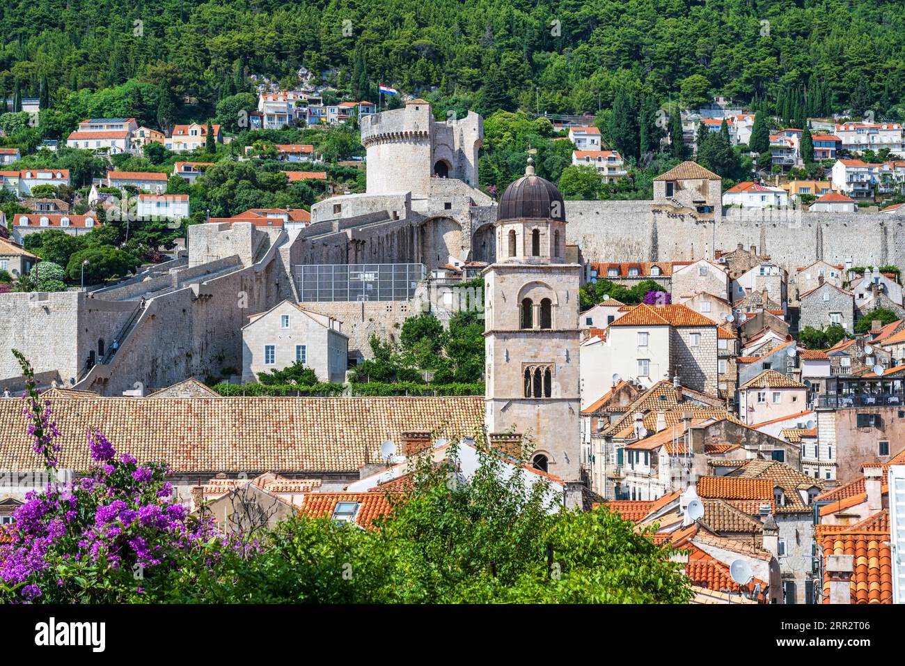 Vista del campanile della chiesa francescana con la torre Minčeta in lontananza nell'antica città fortificata di Dubrovnik, sulla costa dalmata della Croazia Foto Stock