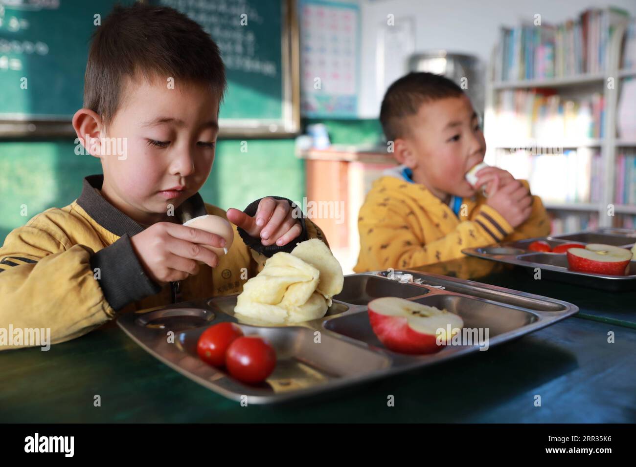 201023 -- HUINING, 23 ottobre 2020 -- gli studenti fanno colazione nella Changshan School, Huining County, provincia del Gansu della Cina nord-occidentale, 22 ottobre 2020. Il 57enne Wang Jianlin è l'unico insegnante della Changshan School. Nel 1987, Wang è stato richiamato da Lanzhou per sostituire suo fratello malato come insegnante di scuola locale e prendersi cura dei suoi studenti. Nel 1997, una malattia oculare acuta catturò Wang, e i suoi occhi si gonfiarono e non riuscivano a vedere la luce. Non è andato dal medico in tempo, perché non voleva sospendere la sua classe. La malattia divenne sempre più grave, e quando fu curato, il damag Foto Stock