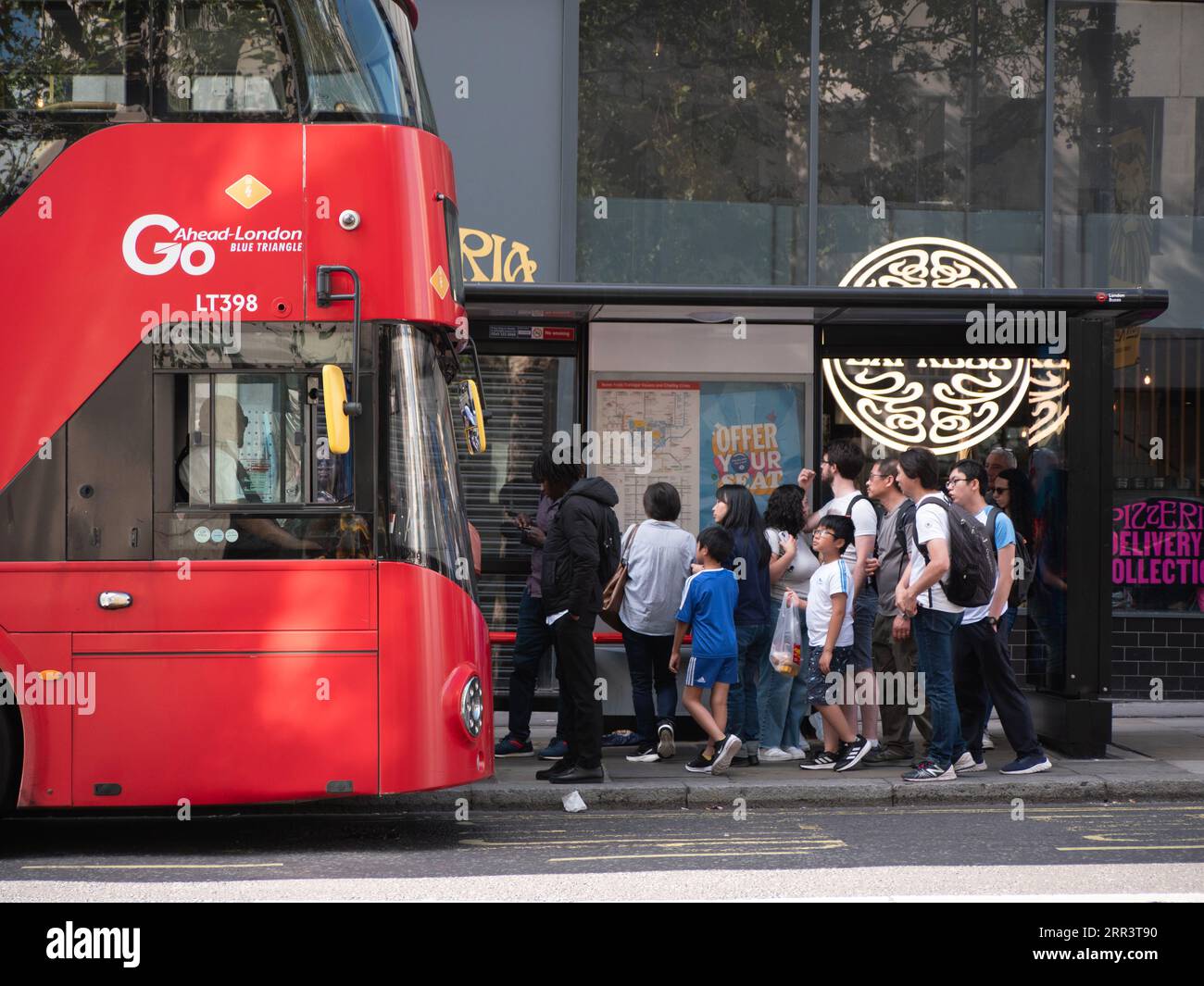 Procedete con il marchio dell'autobus rosso di Londra, lo Strand Central London Foto Stock