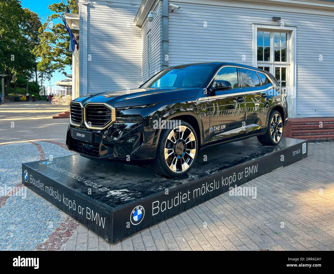 Jurmala, Lettonia - 2 settembre 2023: La nuova BMW XM è esposta sulla strada vicino alla sala concerti Dzintari. Iscrizione sul piedistallo in lettone Foto Stock