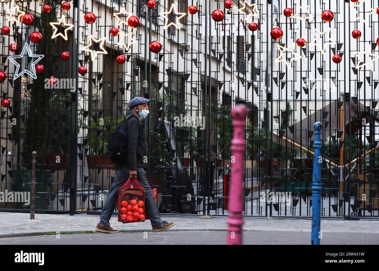 201118 -- PARIGI, 18 novembre 2020 -- Un uomo che indossa una maschera passeggia davanti ad alcune decorazioni natalizie a Parigi, in Francia, 18 novembre 2020. La Francia martedì è diventato il primo paese europeo a registrare oltre due milioni di casi confermati di COVID-19, anche se gli indicatori epidemici stavano gradualmente migliorando, ha detto il direttore generale della salute Jerome Salomon. FRANCE-PARIS-COVID-19-CASI GaoxJing PUBLICATIONxNOTxINxCHN Foto Stock