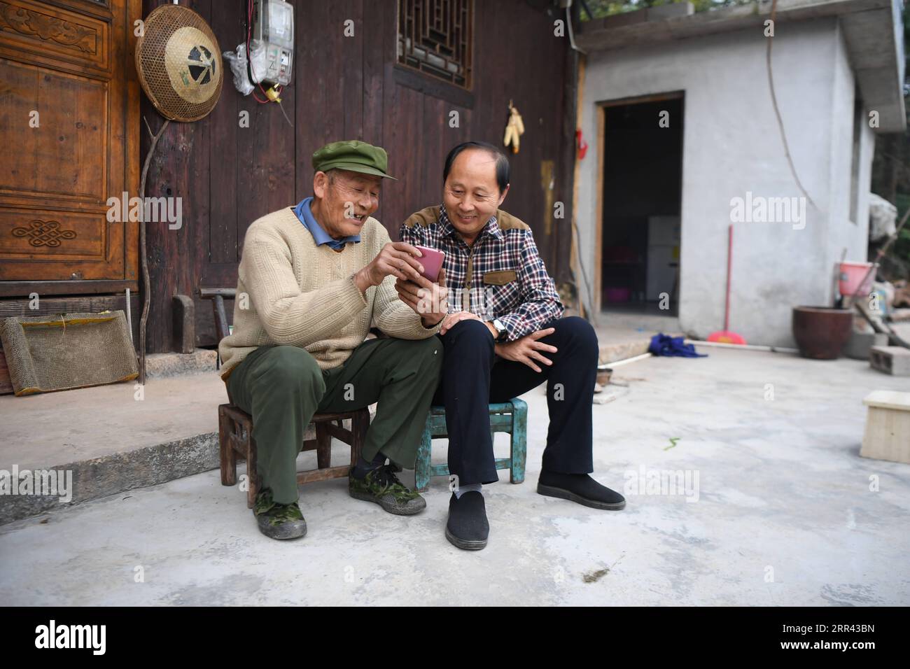 201119 -- XIANGXI, 19 novembre 2020 -- Peng Guofei L mostra i suoi brevi video al villager Peng Hongyun al villaggio Yangmu di Furong Township a Xiangxi Tujia e Miao Autonomous Prefecture, Central China S Hunan Province, 15 novembre 2020. Peng Guofei, 75 anni, è noto online come nonno Fei. È nato e cresciuto nel remoto villaggio di Yangmu situato nelle profondità delle montagne di Wuling. Con l'aiuto di funzionari locali per la lotta alla povertà, gli abitanti del villaggio hanno accesso a Internet negli ultimi anni, poiché l'intero villaggio abbraccia la copertura completa del segnale 4G. All'inizio del 2020, Peng ha seguito corsi Internet nel villaggio per Foto Stock