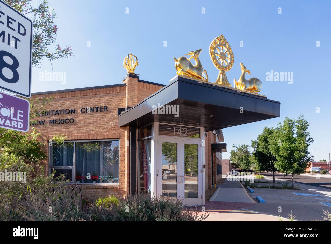 Esterno del Kadampa Meditation Center New Mexico, un edificio in mattoni a un piano con simboli buddisti dorati, dharmacharka e cervi, Albuquerque, USA. Foto Stock