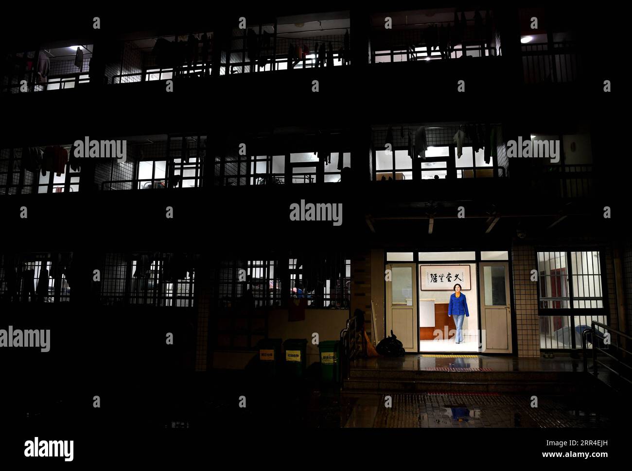 201202 -- WUHU, 2 dicembre 2020 -- Xi Weijing, capo della Wuhu School for the Blind, esce dall'edificio del dormitorio degli studenti dopo un'ispezione serale nella scuola di Wuhu City, nella provincia di Anhui della Cina orientale, 25 novembre 2020. I genitori di XI Weijing sono entrambi ipovedenti. Suo padre Xi Manqiao istituì una scuola privata per non vedenti nel 1979, dedicando tutta la sua energia al lavoro della scuola. Dopo la morte di suo padre di malattia nel 1994, Xi Weijing, allora ventenne, si assunse il peso e divenne il secondo preside della Scuola per ciechi di Wuhu. Con il sostegno del governo locale, il Wuhu Foto Stock