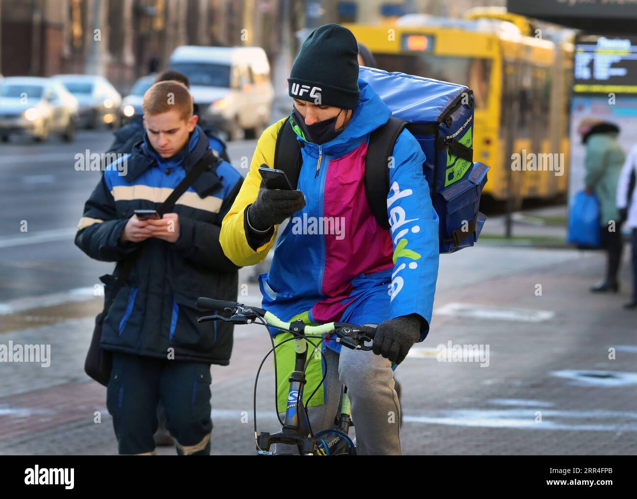 201203 -- MINSK, 3 dicembre 2020 -- Un corriere che indossa una maschera per il viso cavalca una bicicletta per strada a Minsk, Bielorussia, 3 dicembre 2020. La Bielorussia ha segnalato 1.701 nuovi casi di COVID-19 giovedì, portando il suo totale a 141.609, il ministero della salute del paese ha riferito. Finora, 1.181 persone sono morte per la malattia nel paese, di cui sette nelle ultime 24 ore, ha detto. Ci sono stati 1.729 nuovi recuperi nelle ultime 24 ore, portando il totale a 118.924, ha aggiunto il ministero. Foto di /Xinhua BELARUS-MINSK-COVID-19 CASI HenadzxZhinkov PUBLICATIONxNOTxINxCHN Foto Stock