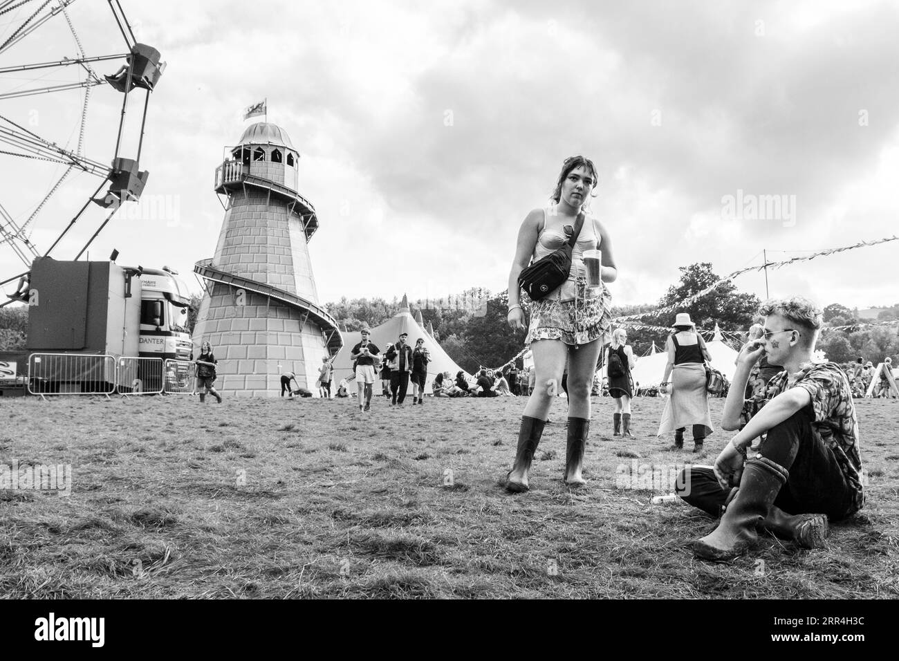 Una giovane coppia nella zona fiarground la donna che tiene una pinta di birra da festival al Green Man Festival, Brecon, Galles, Regno Unito, 2023. Foto: Rob Watkins Foto Stock