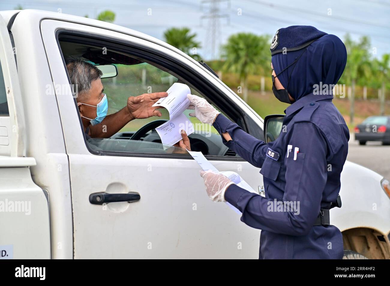 201205 -- SELANGOR, 5 dicembre 2020 -- Un agente di polizia controlla un veicolo in un punto di controllo su un'autostrada a Setia Alam dello stato di Selangor, Malesia, 5 dicembre 2020. Il governo malese ha detto sabato che estenderà l'ordine di controllo del movimento in diverse aree fino al 20 dicembre per controllare la diffusione della COVID-19. Sabato, il Ministero della salute della Malesia ha riportato 1.123 nuovi casi confermati di COVID-19, portando il totale nazionale a 71.359. Foto di /Xinhua MALAYSIA-COVID-19-RESTRICTION-EXTEND ChongxVoonxChung PUBLICATIONxNOTxINxCHN Foto Stock