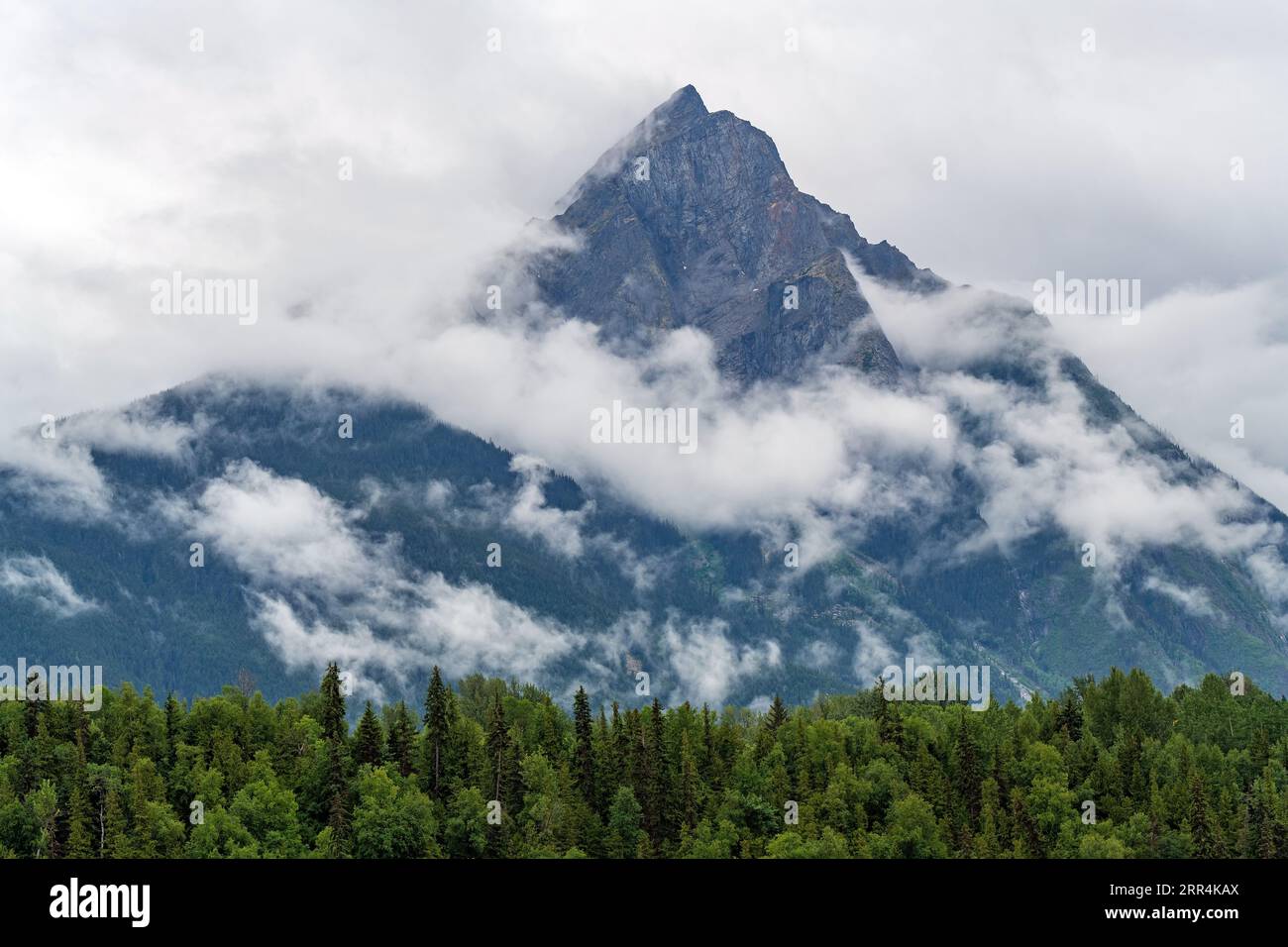 Il picco montuoso di Hagwilget tra le nuvole, Hazelton, British Columbia, Canada. Foto Stock