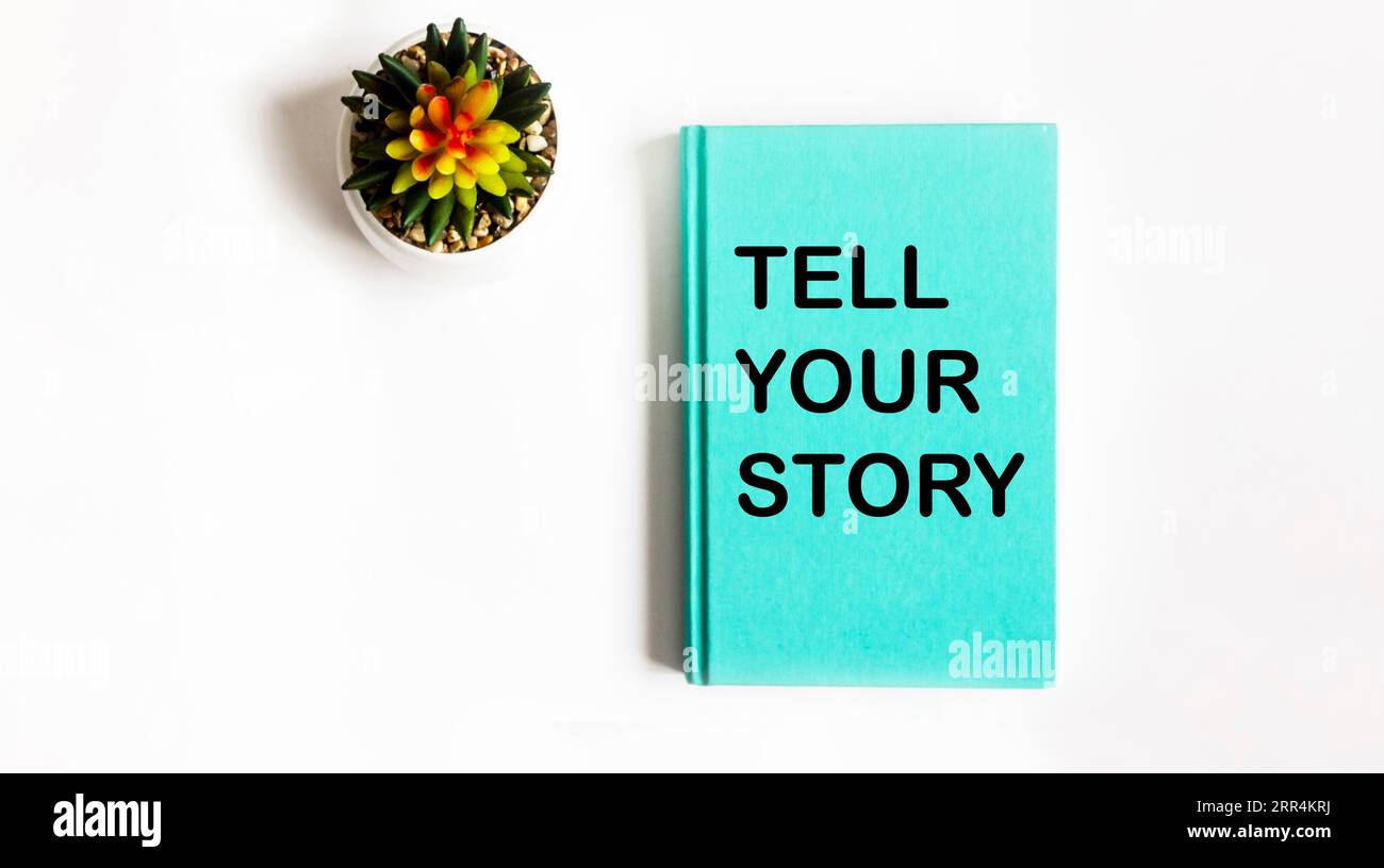 Raccontate il simbolo della vostra storia. Concetto racconta la tua storia su un blocco note e su uno sfondo bianco. Copia spazio. Foto Stock