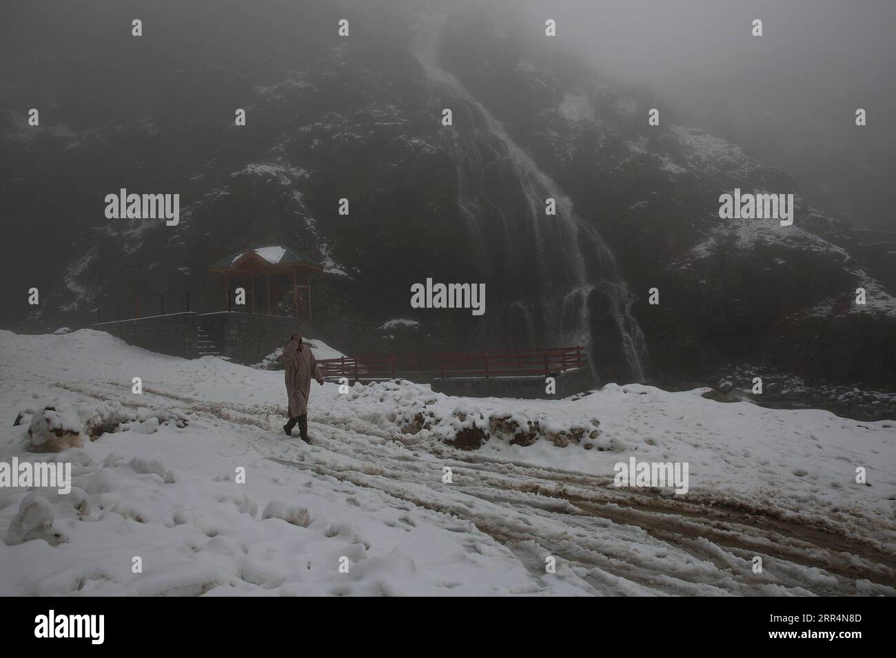 201209 -- SRINAGAR, 9 dicembre 2020 -- Un uomo cammina in mezzo alla nebbia dopo una fresca nevicata in un villaggio nel distretto di Baramulla vicino alla città di Srinagar, la capitale estiva del Kashmir controllato dagli indiani, 9 dicembre 2020. KASHMIR-NEVICATE JavedxDar PUBLICATIONxNOTxINxCHN Foto Stock