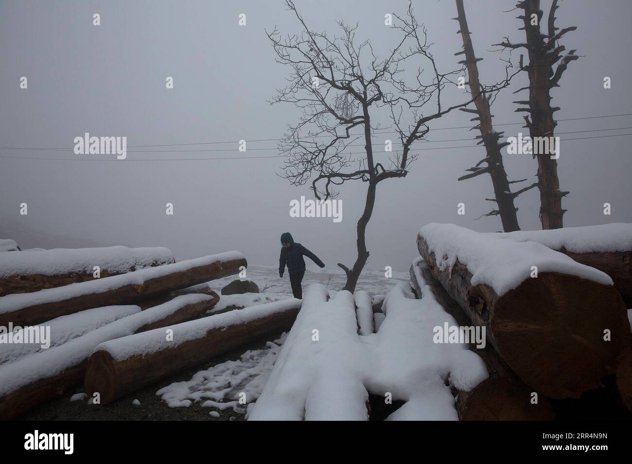 201209 -- SRINAGAR, 9 dicembre 2020 -- Una ragazza cammina in mezzo alla nebbia dopo una fresca nevicata in un villaggio nel distretto di Baramulla vicino alla città di Srinagar, la capitale estiva del Kashmir controllato dagli indiani, 9 dicembre 2020. KASHMIR-NEVICATE JavedxDar PUBLICATIONxNOTxINxCHN Foto Stock