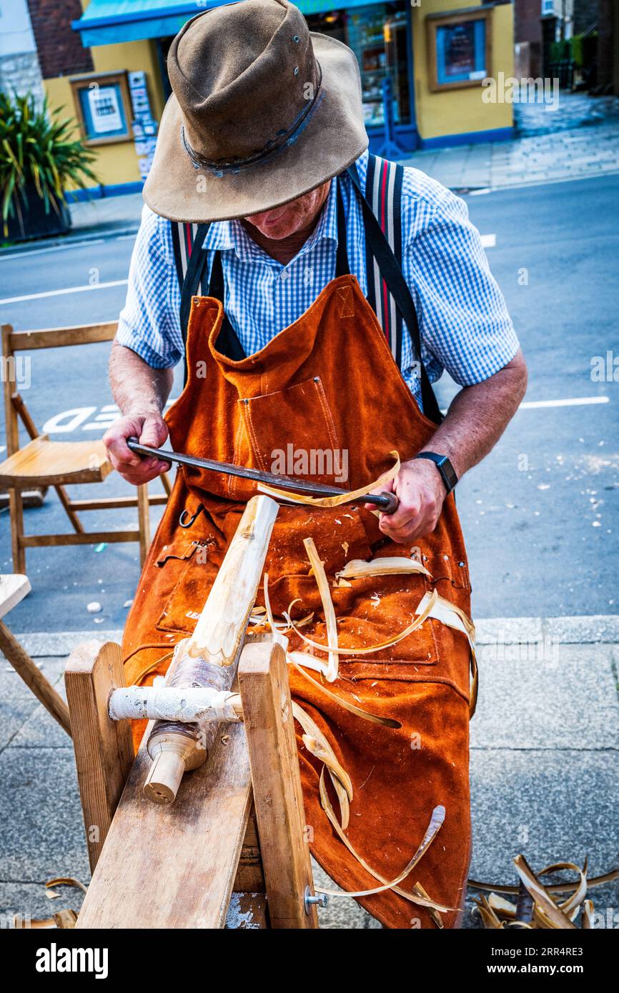 Carpenter lavora nella sua bancarella a Bridport Saturday Street Market. Artigiano concettuale, artigiano, falegname, colorato, tradizionale. Strumenti. Abilità. Foto Stock