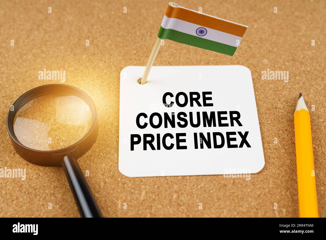 Economia e finanza. Sul tavolo ci sono una lente d'ingrandimento, una matita, la bandiera dell'India e un foglio di carta con l'iscrizione - core consume Foto Stock