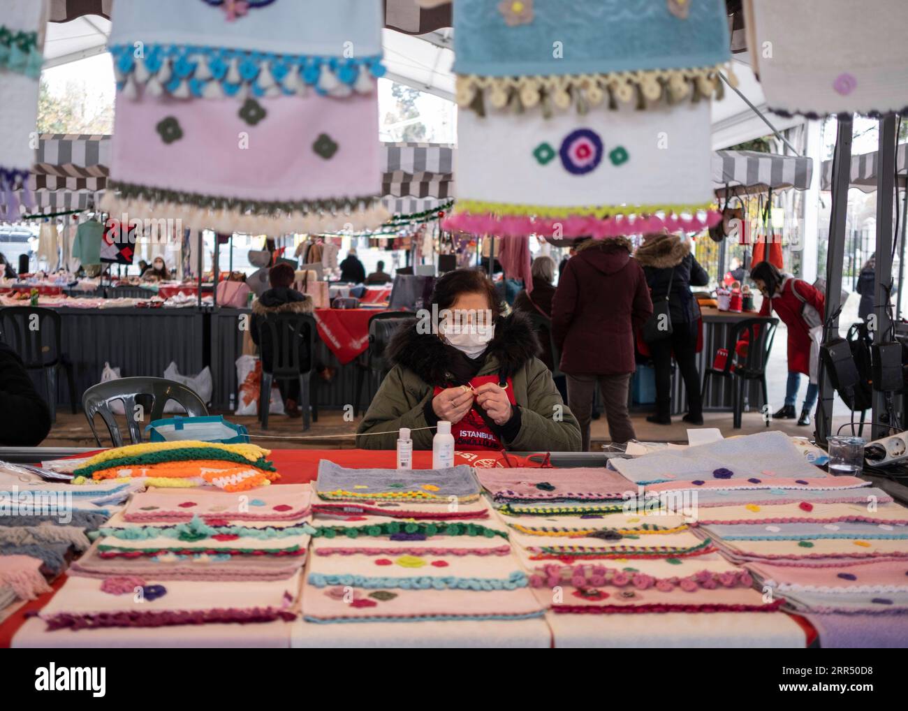 201217 -- ISTANBUL, 17 dicembre 2020 -- Una donna vende oggetti d'artigianato in un bazar a Istanbul, Turchia, il 17 dicembre 2020. Il bazar presso un molo nel quartiere Besiktas di Istanbul è pieno di saponi fatti a mano, giocattoli, pezzi a maglia, oggetti in porcellana e gioielli, tutti prodotti a casa da donne locali. Nell'ambito di un progetto avviato per sostenere l'imprenditorialità femminile, circa 500 donne hanno recentemente iniziato a vendere i loro prodotti al bazar che è stato dato il via lunedì. Foto di /Xinhua TO GO WITH Feature: Il programma imprenditoriale aiuta le donne turche a vendere prodotti fatti in casa TURCHIA-ISTANBUL-WOMEN ENTREPRENEURSHIP OsmanxOr Foto Stock