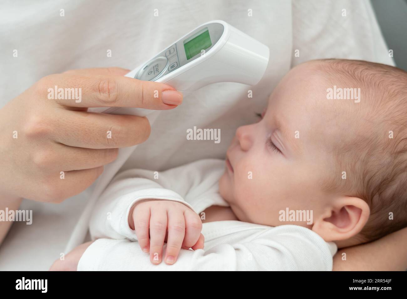 Il tocco della mamma: Monitorare la salute del bambino. Concetto di tecnologia che aiuta gli istinti materni Foto Stock