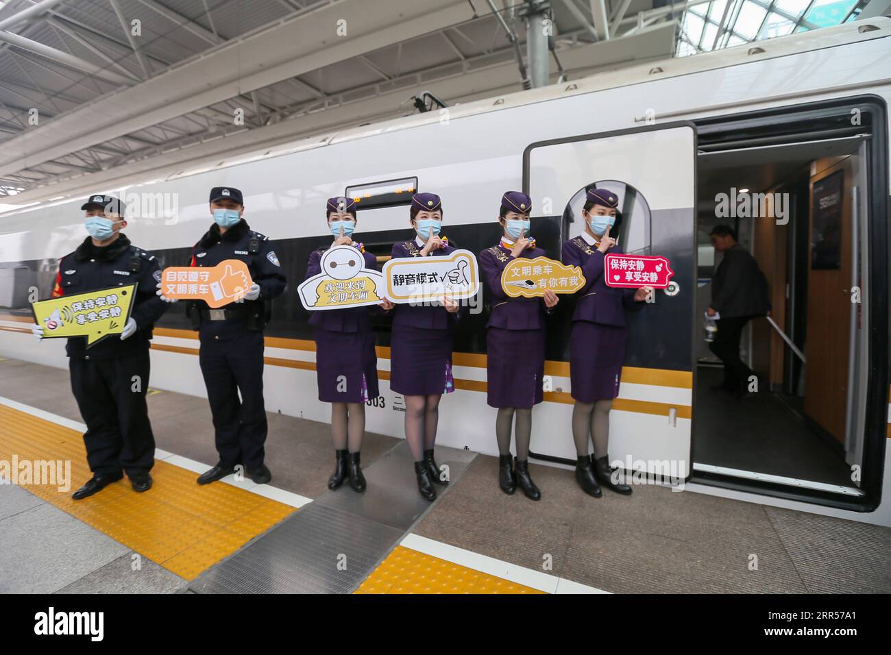 201224 -- SHANGHAI, 24 dicembre 2020 -- i membri del personale promuovono il servizio di auto silenziose di fronte al treno proiettile G2 della ferrovia ad alta velocità Pechino-Shanghai alla stazione ferroviaria di Hongqiao nella Cina orientale Shanghai, 24 dicembre 2020. Alcuni treni ad alta velocità in Cina hanno pilotato auto silenziose per i passeggeri che scelgono un'esperienza di viaggio tranquilla e indisturbata. L'auto silenziosa è spesso la carrozza numero 3 sul treno, con video a bordo silenziati e annunci fatti a un volume inferiore. Le porte alle estremità del carrello vengono chiuse per ridurre il rumore proveniente dall'ingresso. Il servizio è ora disponibile su alcuni tra Foto Stock